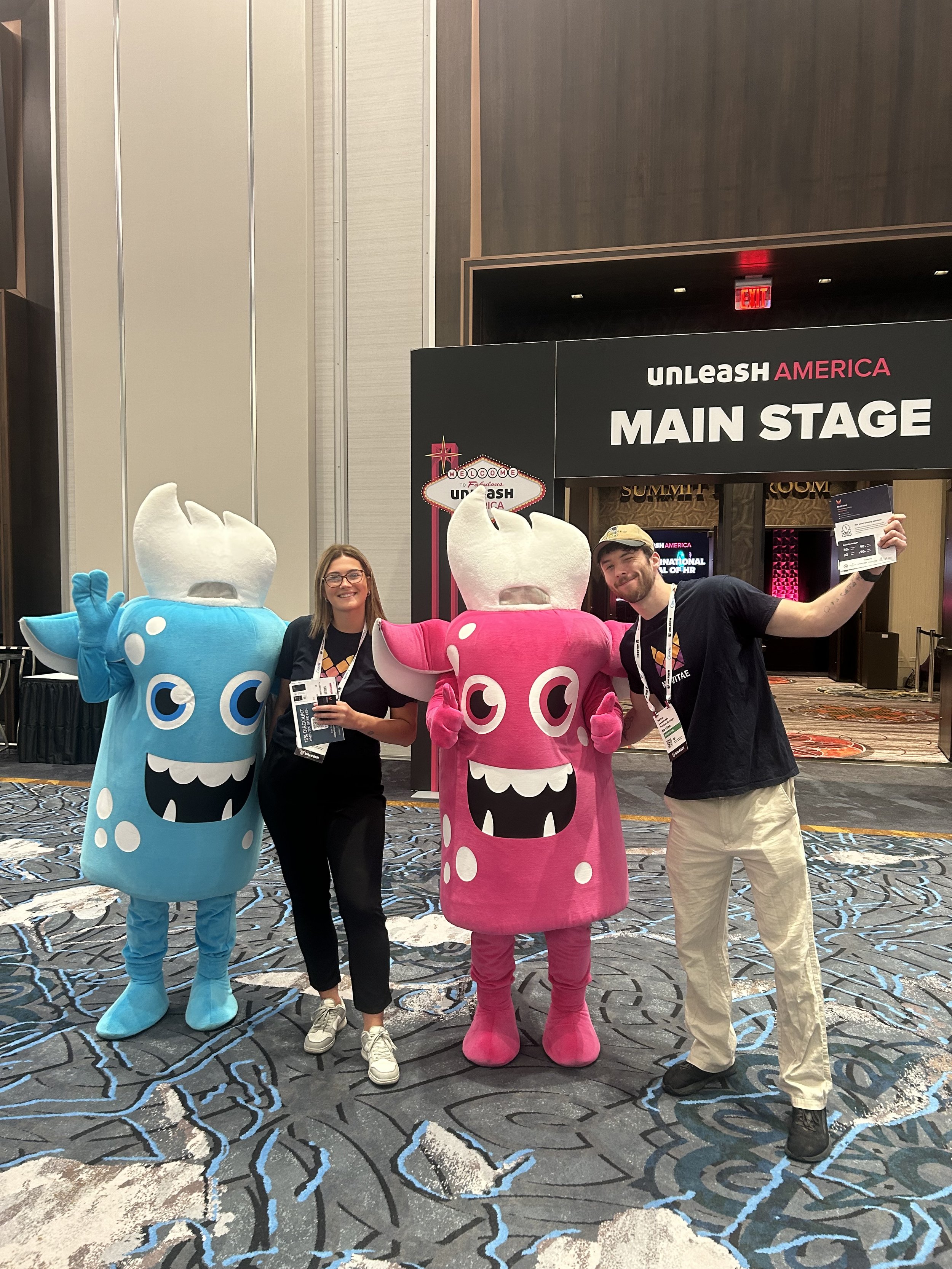 A picture of our team with Unleash America's mascots outside the entrance to Unleash America's main stage